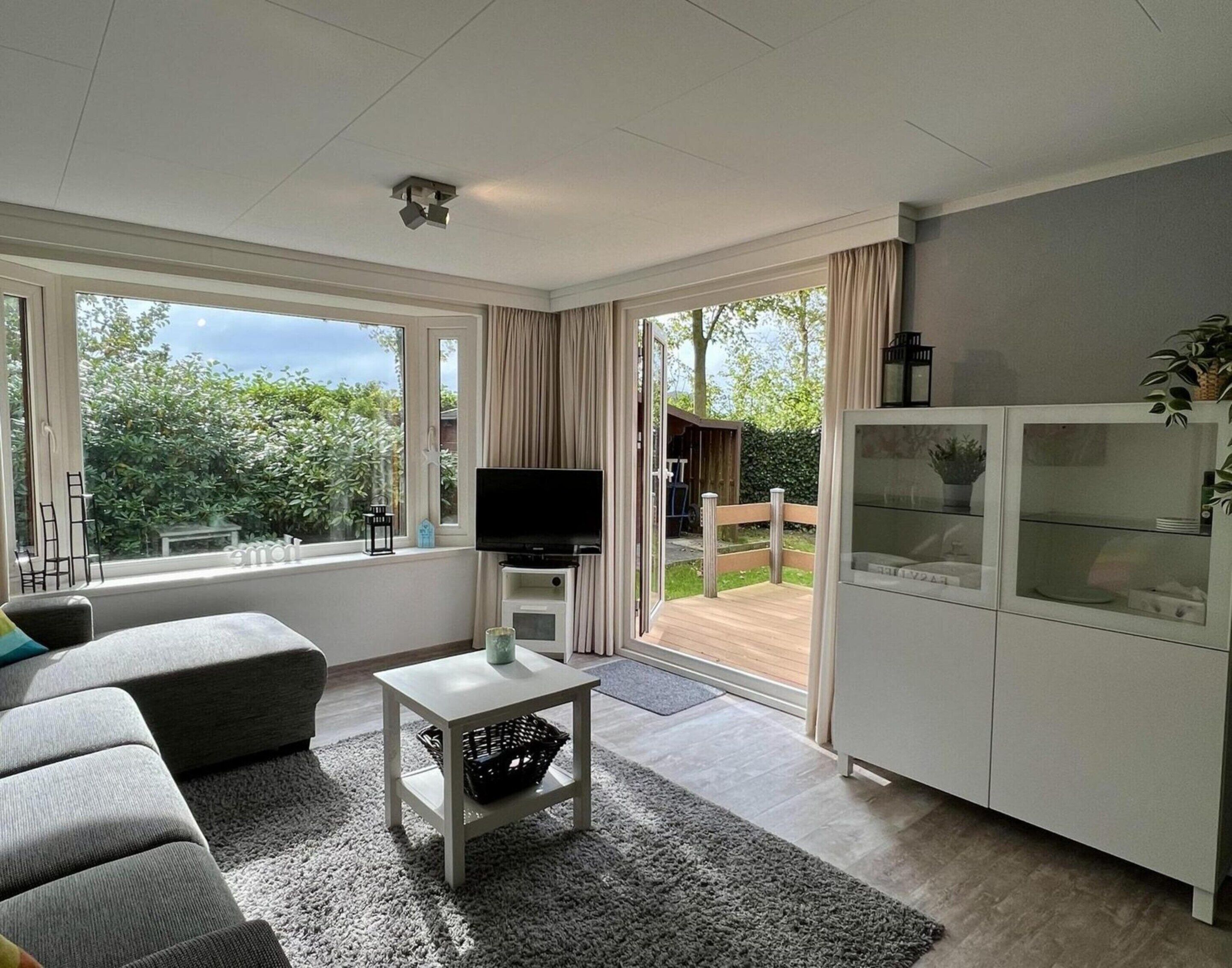 A modern living room with a sofa, TV, and cabinets.