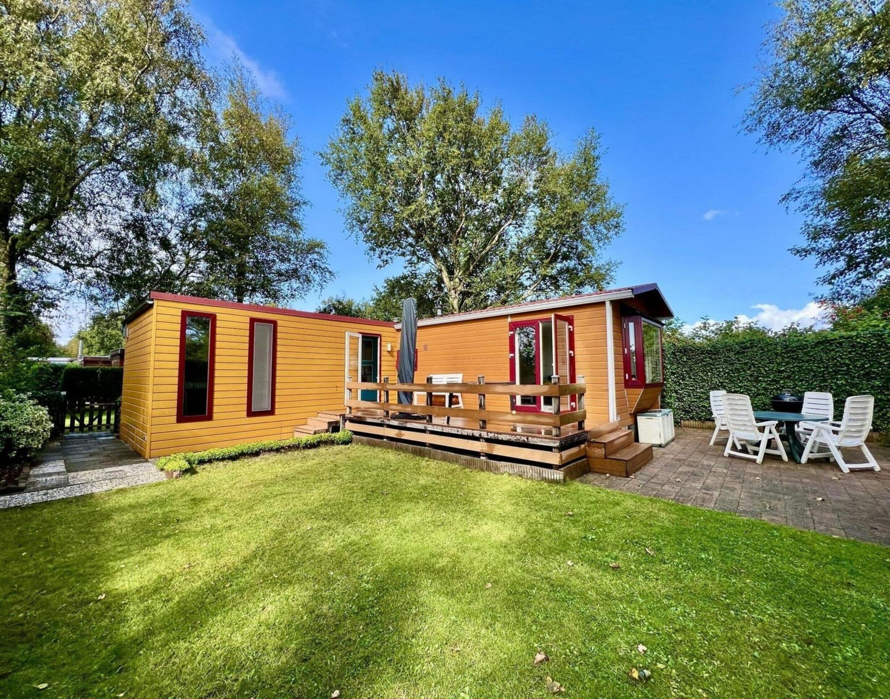 A small wooden cabin with a deck and a patio area.