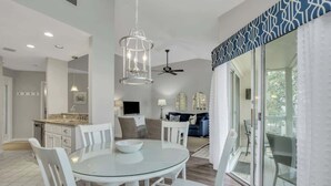 Una cocina moderna con armarios blancos y una mesa redonda de vidrio.