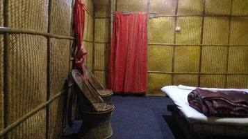 Una habitación con cama, una silla y una mesita.