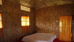 Ein Zimmer mit einem Bett, Holzwänden und einem roten Teppich.
