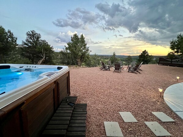 Un jacuzzi con terraza de madera, zona de estar al aire libre y vistas al paisaje.