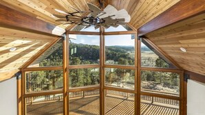 Una habitación con un tragaluz grande y vistas a un paisaje boscoso.