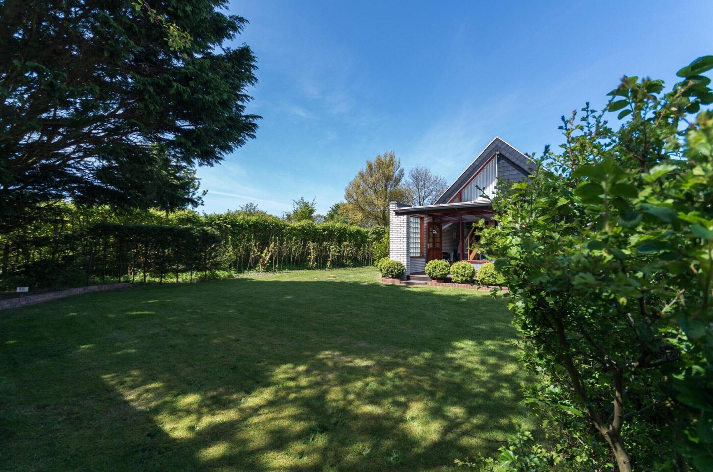 Ein Haus mit gepflegtem Rasen und einer Holzterrasse.