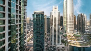 A high-rise building with a curved glass facade, surrounded by other modern skyscrapers. - Lake View Studio near Marina with Pool, Balcony and Gym (Dubai)