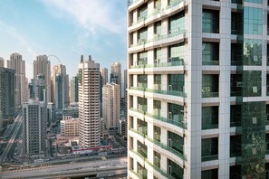 A high-rise building with multiple floors, large windows, and a modern architectural design. - Lake View Studio near Marina with Pool, Sauna and Gym (Dubai)