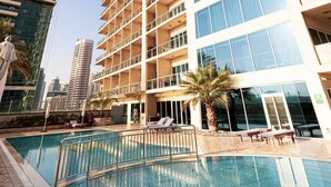 A high-rise hotel with a swimming pool and multiple balconies. - Lake View Studio near Marina with Pool, Sauna and Gym (Dubai)
