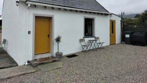 A small white building with a grey roof, two doors, and a window. - Creeslough - 2 Bed Cottage - Pet Friendly - Garden (Glenveagh)