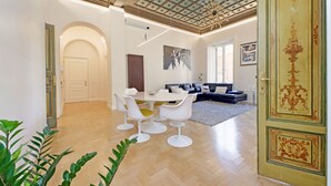 A spacious living area with a dining table and chairs, a sofa, and a decorative ceiling. - Rare Large and Elegant Rome Apartment in Prati Neighborhood Perfect for Families or Friends (Rome)