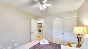 A bedroom with a bed, a ceiling fan, a lamp, and a door leading to a laundry area. - 5 Mi to Downtown - Peaceful Home in Casa Grande (Casa Grande)