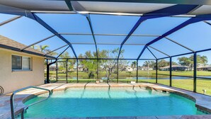 Piscina interior con vista despejada al exterior, rodeada por una estructura de metal.