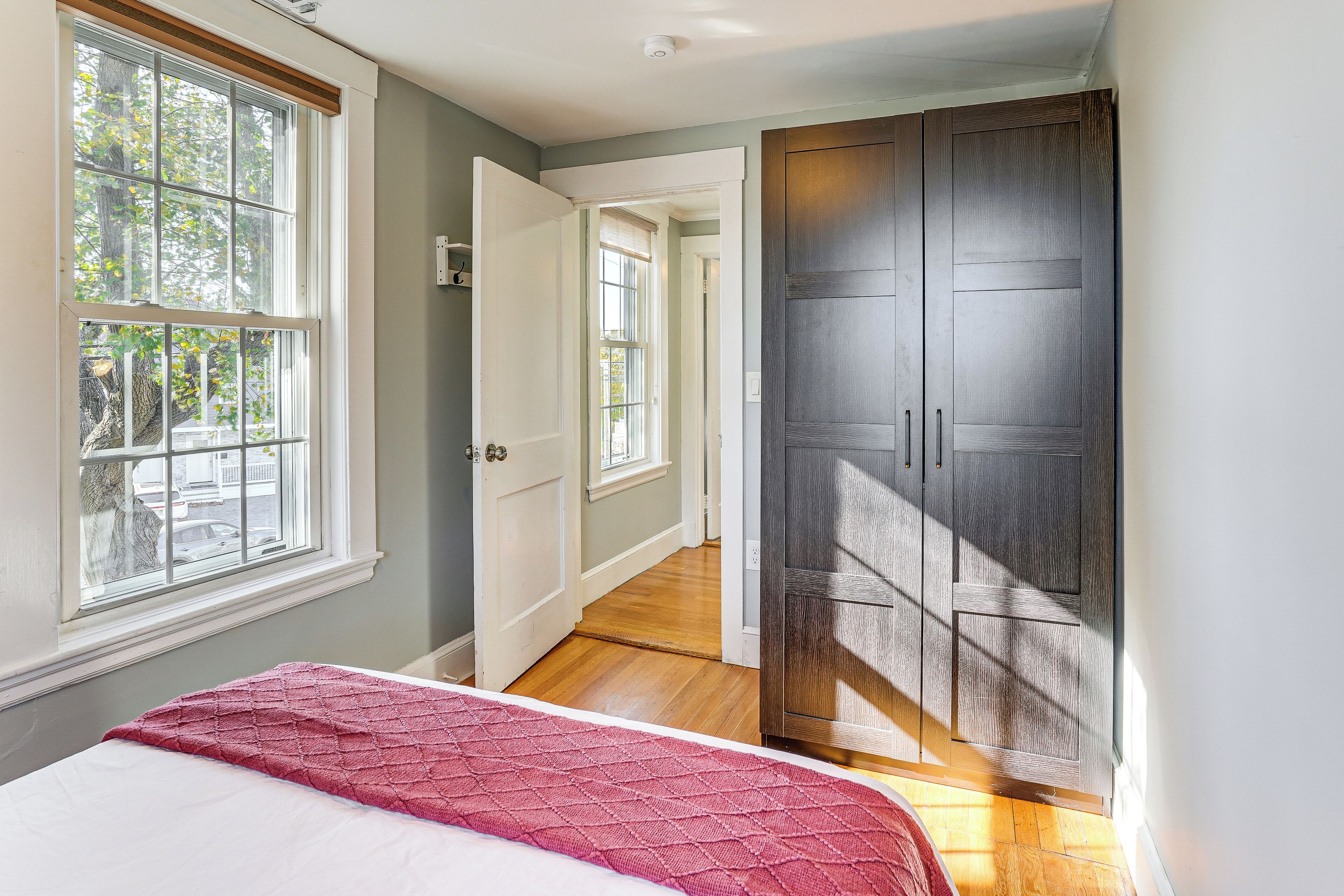 A bedroom with a bed, a window, and a wardrobe.