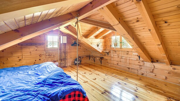 A wooden cabin with a loft bedroom, a rope swing, and a small window. - Bellevue Log Cabin w/ Gas Grill & Creek Access (Bellevue)