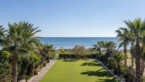 A well-maintained lawn with a wooden pathway leading to a beach view. - Ayia Napa Seafront Ionion Villa H5 (Sotira)