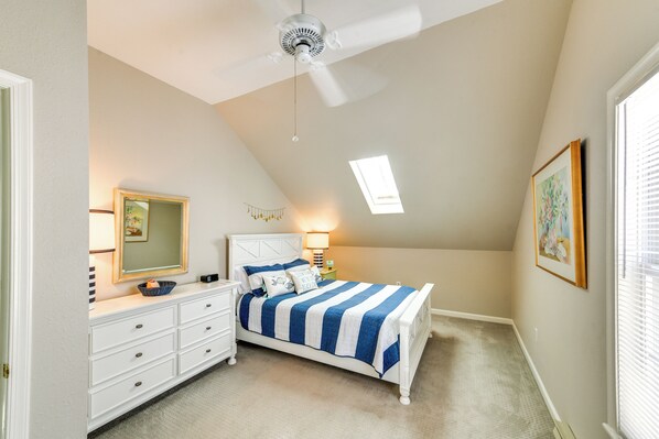 Une chambre à coucher avec un lit, une commode et un ventilateur de plafond.