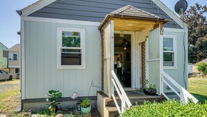 Ein kleines, eingeschossiges Haus mit Veranda, Satellitenschüssel und Blumentopf.