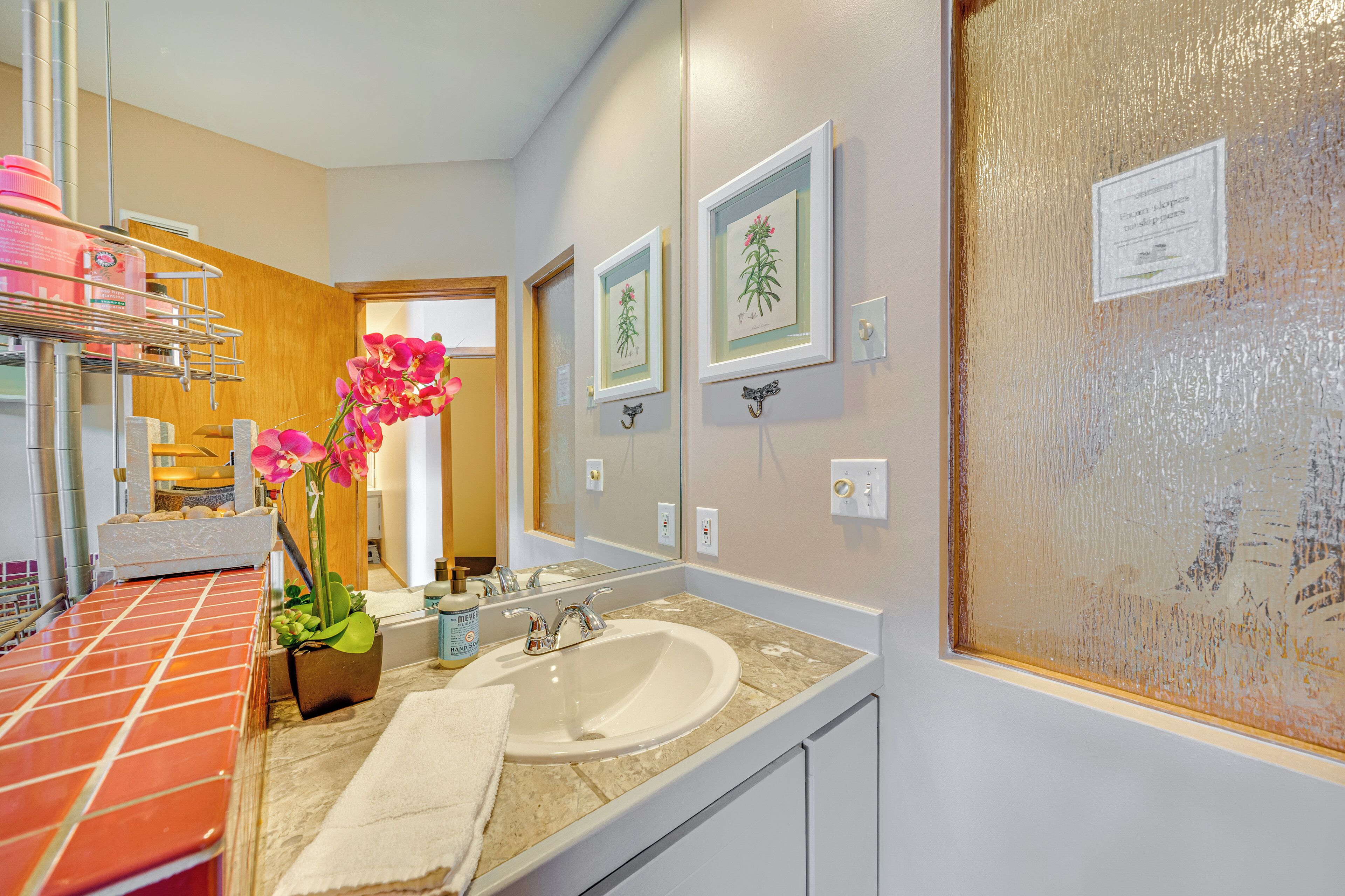 Une salle de bain moderne avec un grand lavabo, un miroir et un espace douche.