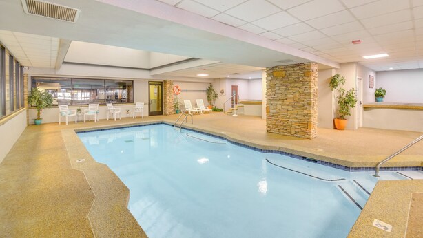 An indoor swimming pool with lounge chairs and a stone wall. - Pool + Hot Tub Access: Condo in Winter Park! (Winter Park)