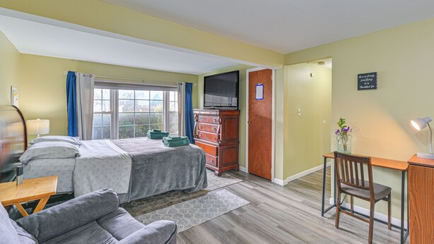 A hotel room with a bed, a desk, a chair, a dresser, and a television. - 2 Mi to UBS Arena: Wfh-friendly Couple's Retreat (Floral Park)