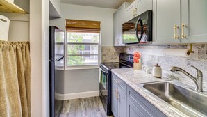A kitchen with a refrigerator, oven, microwave, and sink. - Half-mi to Ocean: Cape Canaveral Beach Hideaway! (Cape Canaveral)