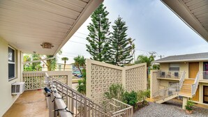 A hotel courtyard with a covered walkway, a small pool, and a building with a balcony. - Half-mi to Ocean: Cape Canaveral Beach Hideaway! (Cape Canaveral)