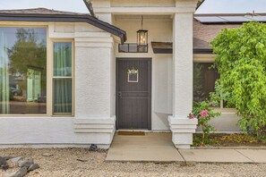 A house with a dark front door, a small porch, and a large window. - Seasonally Heated Pool: Phoenix Family Home! (Phoenix)