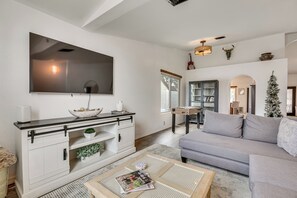 A modern living room with a flat-screen TV, a sofa, a coffee table, and a fireplace. - Seasonally Heated Pool: Phoenix Family Home! (Phoenix)