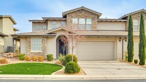 A two-story house with a stone facade, a garage, and a well-maintained lawn. - Hike, Bike & Swim: Utah Family Home w/ Mtn Views! (Washington)