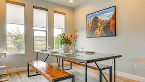 A dining area with a glass table, benches, and a large window with blinds. - Hike, Bike & Swim: Utah Family Home w/ Mtn Views! (Washington)