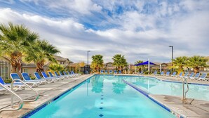 A swimming pool with blue water, surrounded by lounge chairs and palm trees. - Hike, Bike & Swim: Utah Family Home w/ Mtn Views! (Washington)