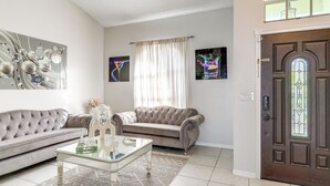A living room with a tufted sofa, a glass coffee table, and a patterned rug. - 3 Mi to Marina: Riverview Family Home w/ Lanai! (Riverview)