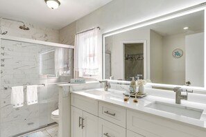 A modern bathroom with a glass-enclosed shower, a large mirror, and a white vanity with a sink. - 3 Mi to Marina: Riverview Family Home w/ Lanai! (Riverview)