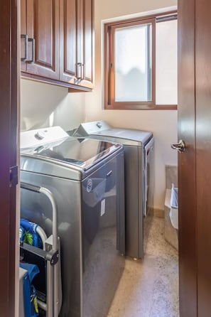 A compact kitchen with a built-in washing machine and a window above the sink.