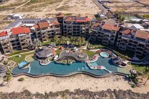 Ein Resort mit mehreren Gebäuden, einem zentralen Pool und einem Strandbereich.