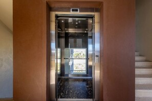 Ein Aufzug mit digitaler Anzeige, Glastür und Metallausstattung.