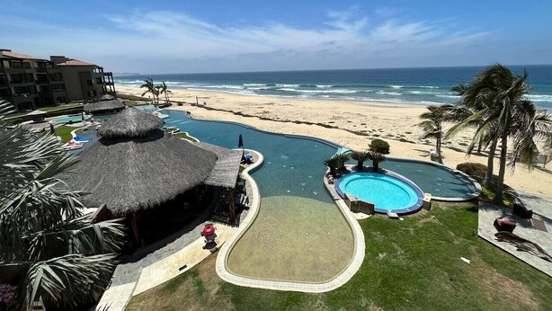 Resort com piscina, praia e vista para o oceano.