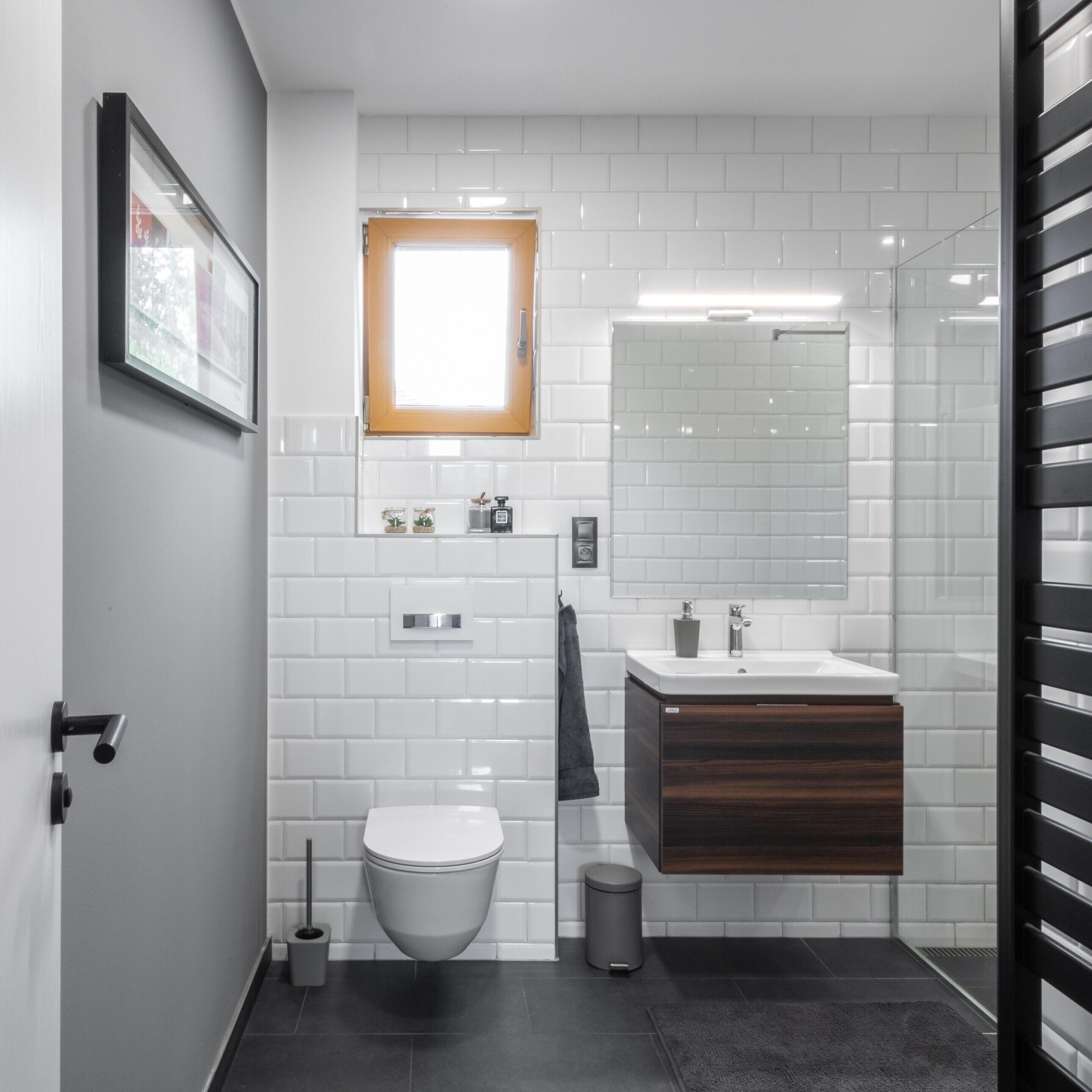 Ein modernes Badezimmer mit Toilette, Waschbecken und Spiegel.