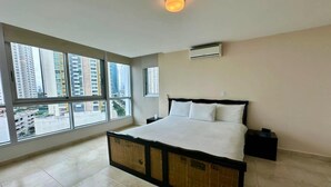 A bedroom with a large bed, a window, and an air conditioning unit. - River Wood I Sunny 1 BDR in Costa del Este (Panama City)