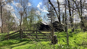A rustic barn surrounded by lush greenery and a wooden fence. - Relaxing Holiday Home Near Beach (Sint Maartensvlotbrug)
