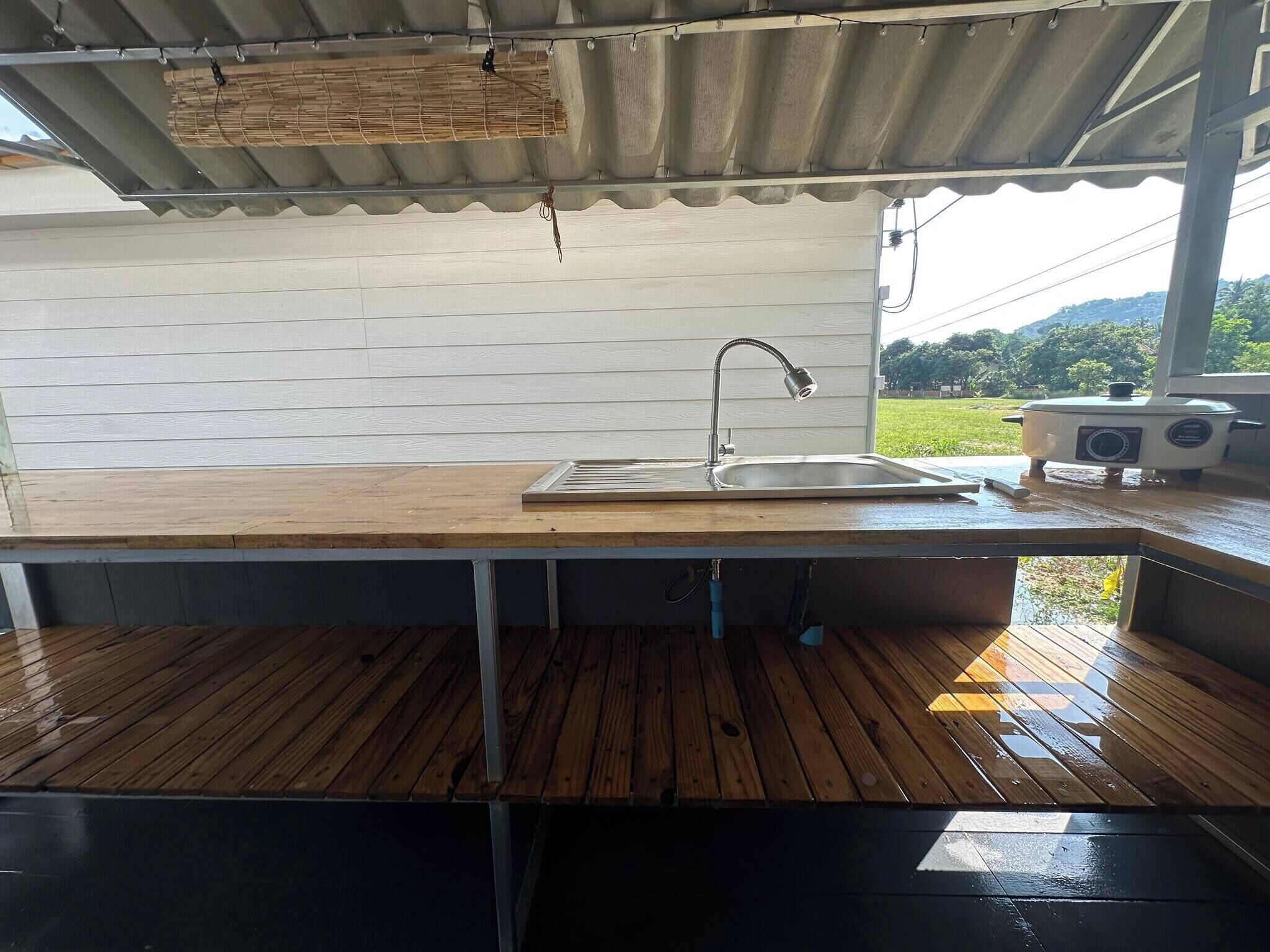 A kitchen with a wooden countertop, a sink, and a stove.