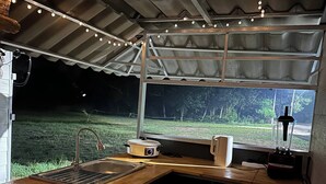 A kitchen with a wooden countertop, a sink, a stove, and a window overlooking a grassy area. - 1BR Mountain View #2 - 1000mbps WiFi (Ko Pha-ngan)
