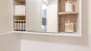 A bathroom with a vanity unit containing toiletries and a mirror. - Stylish & fully equipped apt. only 5 min to metro. Nice area near the Bastille.  (Paris)