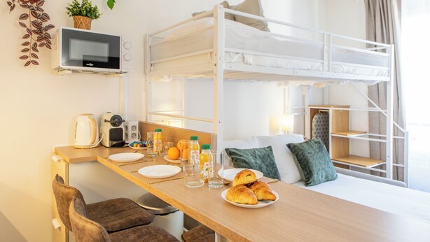 A bunk bed room with a kitchenette, breakfast setup, and a plant on the wall. - Stylish & fully equipped apt. only 5 min to metro. Nice area near the Bastille.  (Paris)