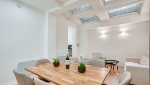 A modern dining area with a wooden table, chairs, and potted plants.