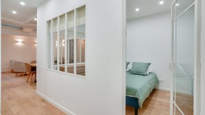 A modern bedroom with a bed, a desk, and a chair.