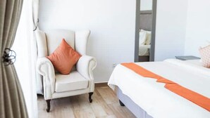 Une chambre d’hôtel avec un lit, une chaise et un miroir.