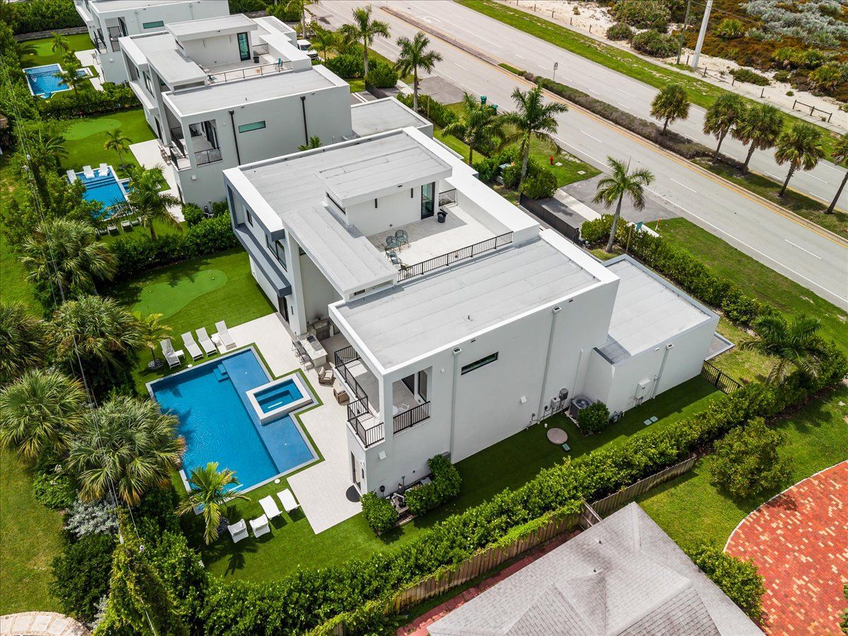 A modern multi-story residential building with a swimming pool and landscaped gardens.