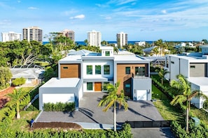 Un moderno edificio residencial con techo plano, amplias ventanas y un césped cuidado.