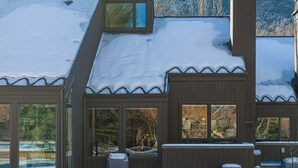 Un edificio moderno con amplios ventanales y un techo cubierto de nieve.