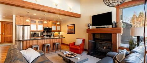 A modern living room with a leather sofa, a coffee table, and a fireplace.